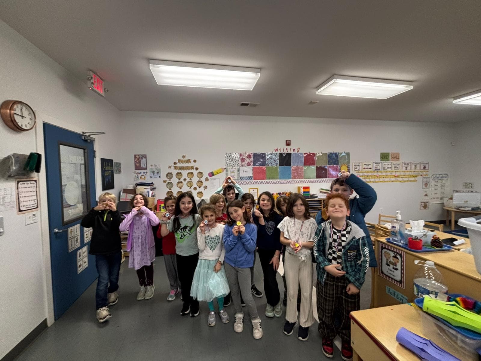 A large group of children holding craft projects